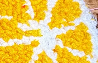 Nahaufnahme Loop Pile: breite weiße Trennlinien zwischen gelben Segmenten der Orangenscheibe, deutlich sichtbare Schlingen.