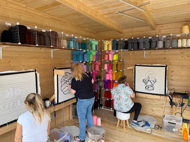 Teilnehmerinnen tuften ihre eigenen Motive an der bunten Garnwand im Fadenzoo-Studio in Marl